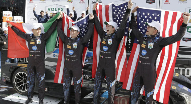 Il pilota Max Angelelli (a sinistra) sul podio della 24 Ore di Daytona con la bandiera italiana